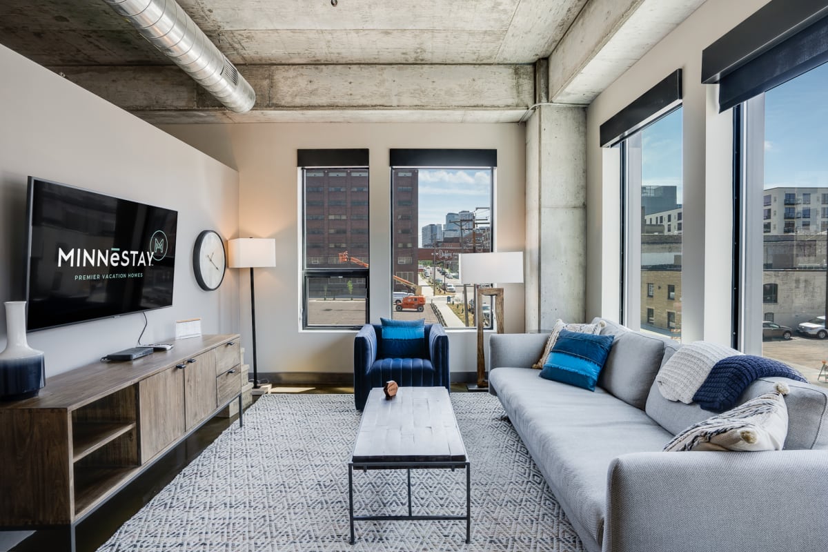 Unwind in your stylish loft with exposed concrete ceilings and panoramic city views through floor-to-ceiling windows.