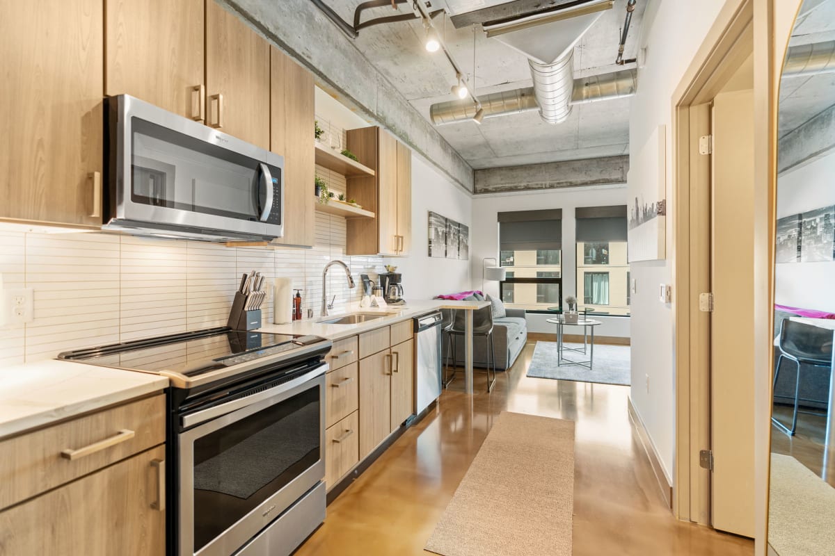 Your modern kitchen features sleek appliances and warm wood cabinetry, perfect for preparing meals in this stylish urban retreat.