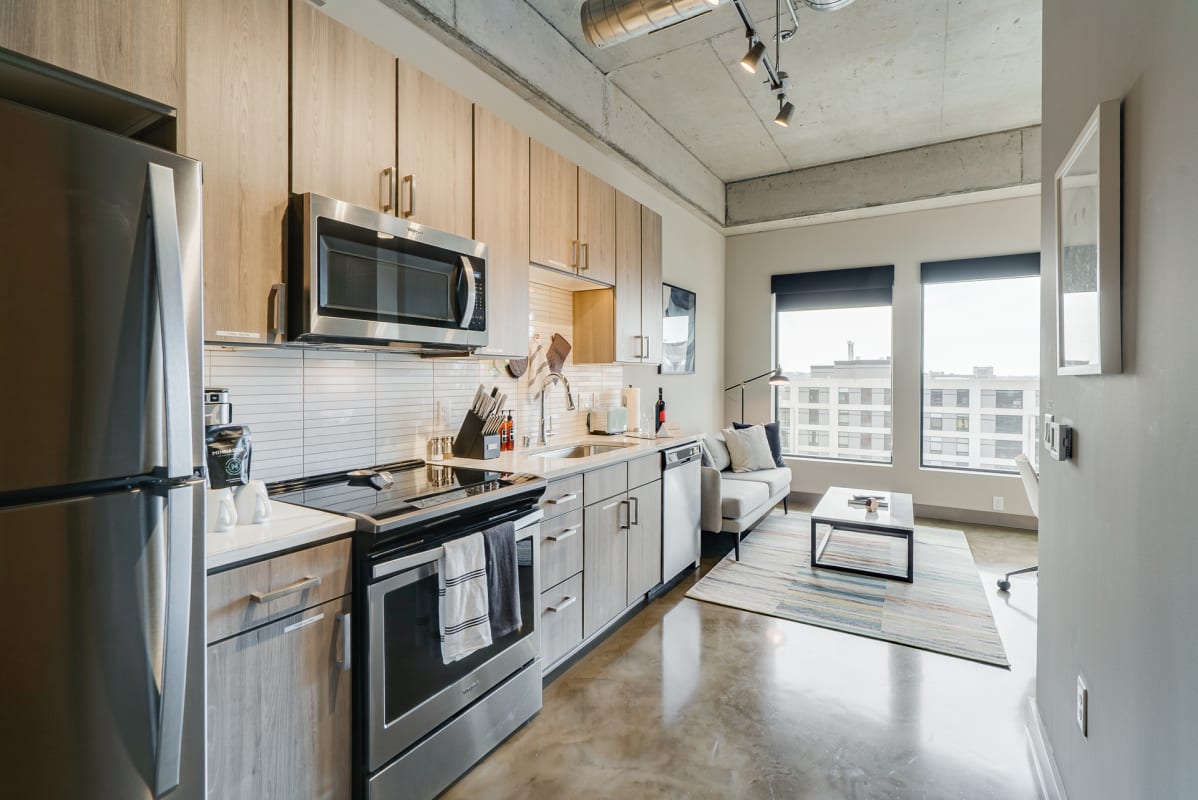 Your modern loft features a fully equipped kitchen with stainless steel appliances and flows seamlessly into a cozy living area with city views.
