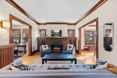 Cozy living room featuring a brick fireplace, modern television, and stylish furniture.