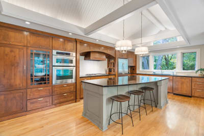 Modern kitchen with wooden cabinets and an island with bar stools.