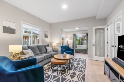 Modern living room with gray walls, sectional sofa, blue armchairs, and decorative accents