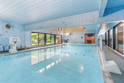 Indoor swimming pool area with light blue walls and clear water.