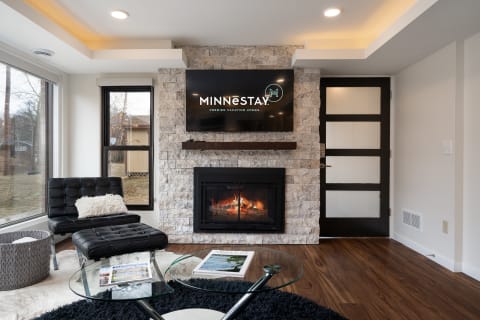 Modern living room with a stone fireplace and flat-screen TV.