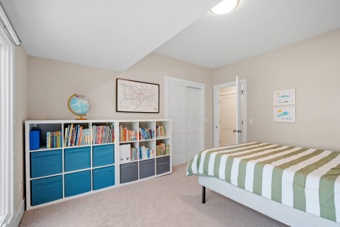 A bright children's bedroom with a bookshelf, globe, and colorful decorations.