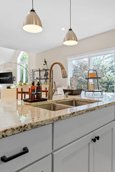 Contemporary kitchen featuring a granite countertop, stainless steel faucet, and stylish decor.