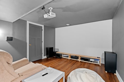 Cozy home theater room featuring a recliner, projector, and speakers.