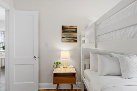 Interior view of a bedroom featuring a wooden bunk bed and marble-topped nightstand.