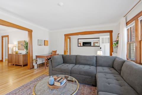 Cozy living room with gray sectional sofa and wooden furniture.