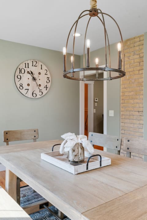 Cozy dining area featuring a wooden table, rustic chandelier, and decorative elements.