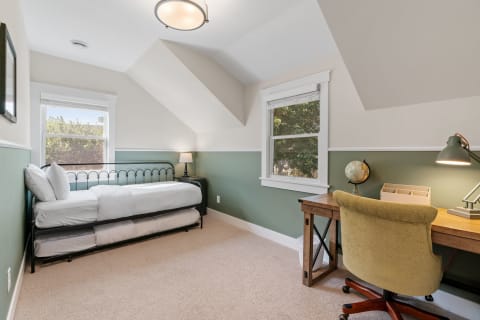 Cozy bedroom with a daybed and wooden desk.