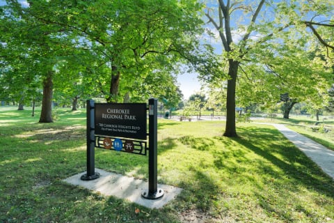 Sign for Cherokee Regional Park surrounded by green trees and grass.