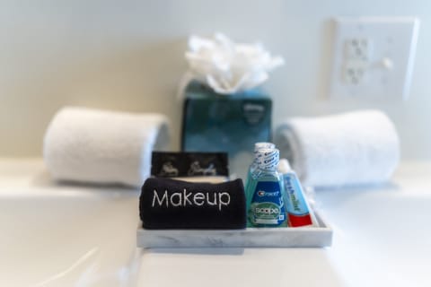 Bathroom countertop with makeup towel, mouthwash, toothpaste, and tissue box.