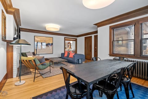 Living and dining room with modern furnishings and wooden accents.