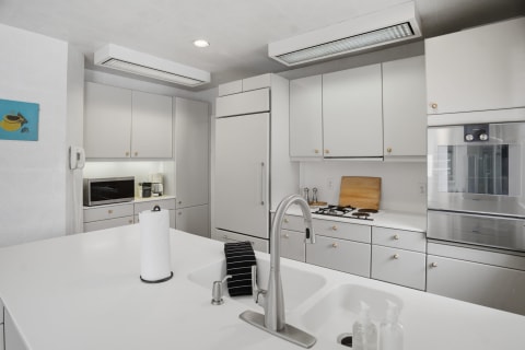 Modern kitchen featuring white cabinetry, stainless steel appliances, and a spacious island with countertop space.