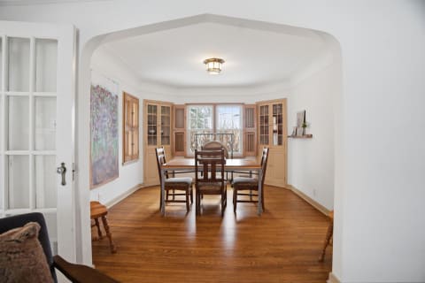 Elegant dining room with wood floors, built-in cabinetry, and arched ceilings.