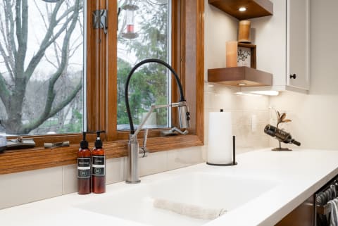 Modern kitchen sink with a window view and stylish decor.