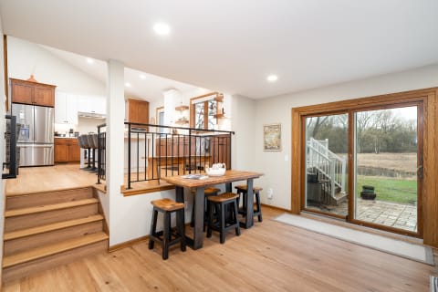 Modern kitchen and dining area featuring wood accents and sliding glass doors leading to an outdoor space.