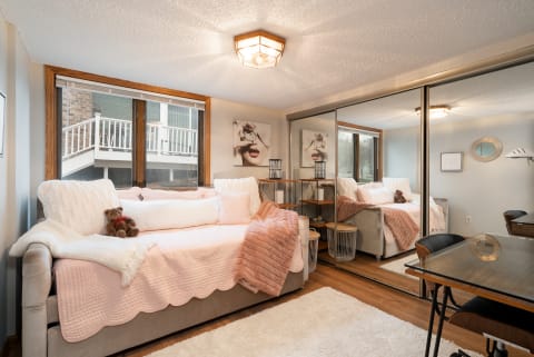 A cozy living room featuring a couch, large windows, and decorative elements.