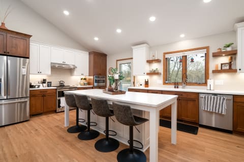 Bright and spacious kitchen with a large island, wooden cabinets, and stainless steel appliances.