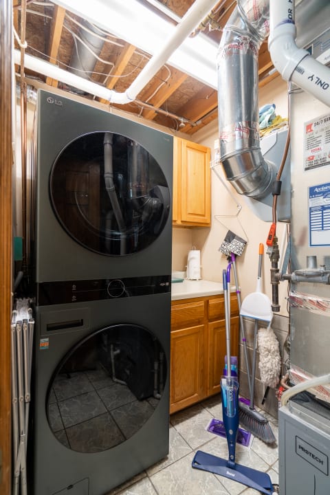 Laundry room with black LG washer-dryer unit and cleaning supplies.