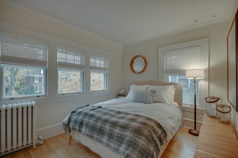 Drift off in your peaceful bedroom with natural light streaming through windows overlooking quiet autumn views.
