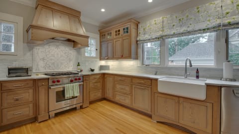 Cook memorable meals in this spacious kitchen with gleaming countertops, professional-grade appliances, and warm wood cabinetry.