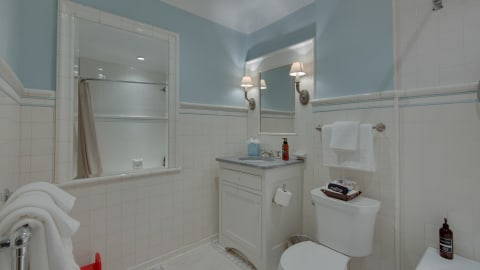 Elegant bathroom with blue walls, white fixtures, and stylish amenities.