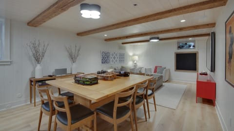 Inviting dining area with wooden beams, a large table, and a cozy seating arrangement.