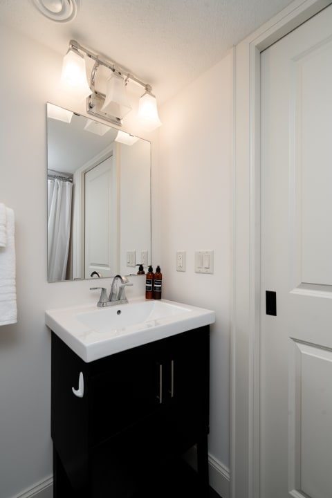 Sleek bathroom featuring a black vanity and modern fixtures.
