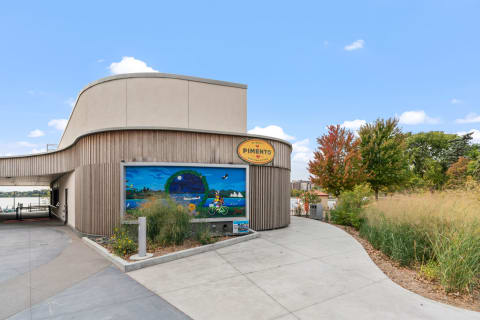 A contemporary building with a mural and greenery, labeled 'Pimento'.