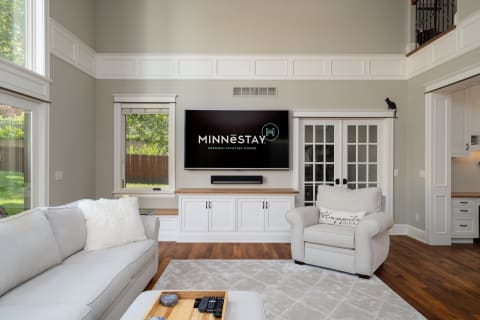 Modern living room featuring a sectional sofa, a large TV, and a playful black cat.