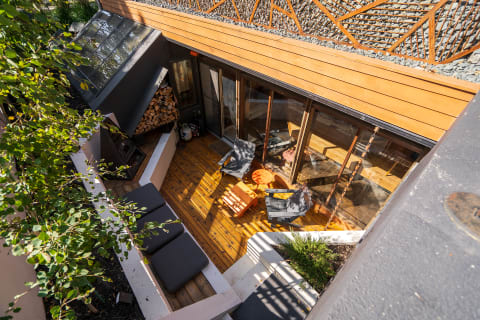 An aerial view of a contemporary outdoor patio with wooden decking and modern furniture