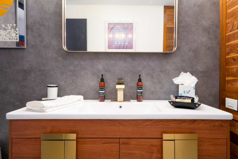 Modern bathroom countertop featuring a sink, towel, and toiletries.