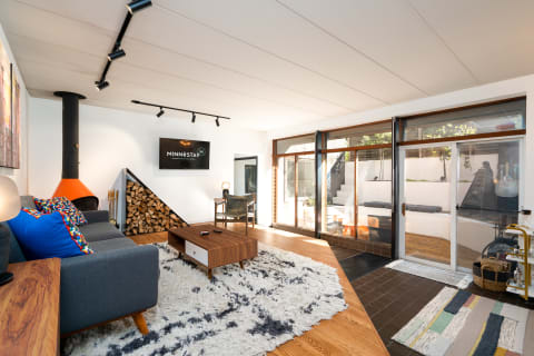 Modern living room with gray sofa, fireplace, and sliding glass doors leading to an outdoor area.