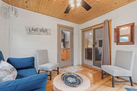 Cozy lake house living room with wooden paneling and comfortable seating.