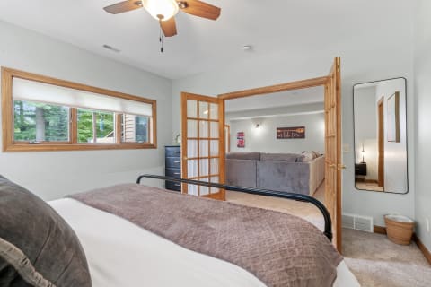 Cozy bedroom with a view of greenery and connected living space.