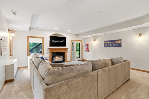 Cozy living room with a beige sectional sofa, fireplace, and TV.