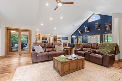 Cozy living room featuring leather couches, rustic coffee table, and vaulted ceilings.