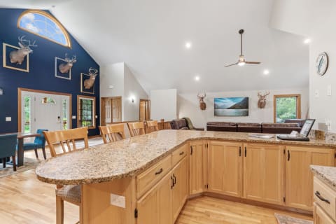Interior view of a home with a modern kitchen and rustic elements, including deer mounts on the wall.