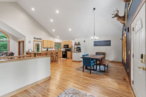 Interior of a home featuring an open kitchen and dining area with modern furnishings and wooden accents.
