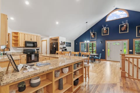 Bright and spacious kitchen featuring granite countertops and navy blue accent wall.