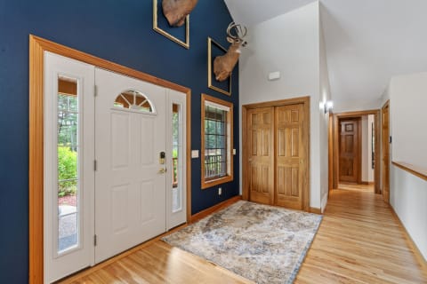 An inviting entryway featuring a white double door, blue walls, and taxidermy decor.