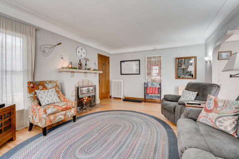 Inviting living room featuring a fireplace, colorful armchair, and decorative elements.