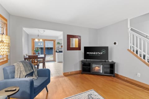 Living room with blue armchair and dining area in the background.