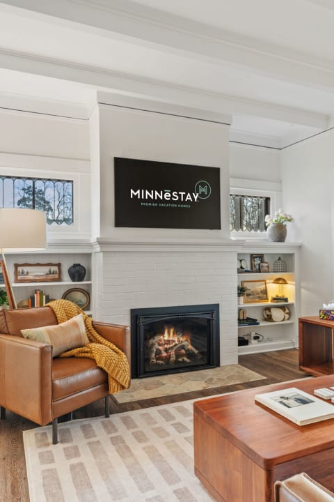 Cozy living room with leather seating, fireplace, and built-in shelves.