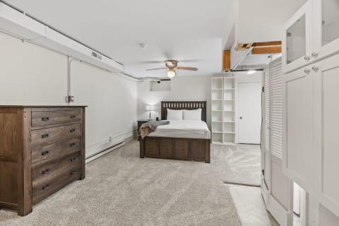 Cozy basement bedroom with wooden furniture and soft carpeting.