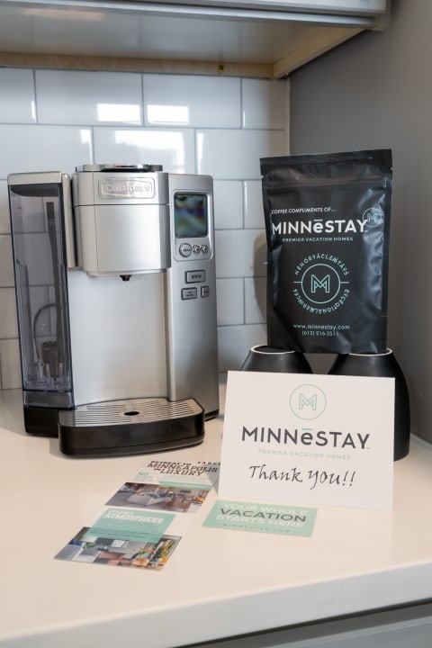 Coffee maker with promotional materials from MINNēSTAY vacation homes.