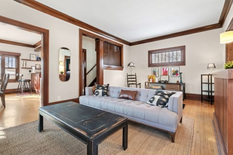 Living room with light gray sectional sofa, black coffee table, and wooden accents.