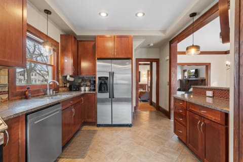 Inviting kitchen with rich wooden cabinets and stainless steel appliances.